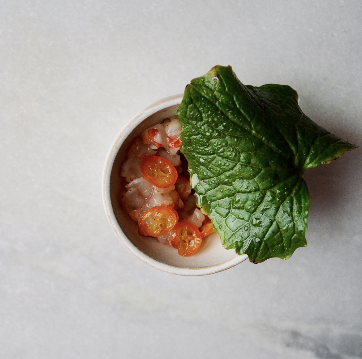 Tartar de gamba solpleteada/ kumquats asados con sal/ hoja de wasabi